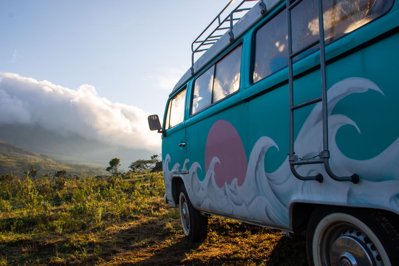 A tour van driving a mountain road at sunrise